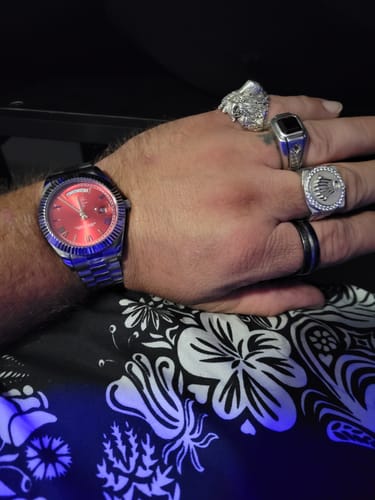 Reviewer wearing the Lucky Fours® Santos watch with a vibrant red face on their wrist.
