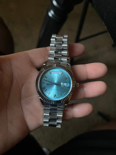 Close-up of a customer holding the silver Lucky Fours® Santos watch with a light blue dial.