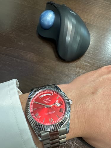 Customer wearing the Lucky Fours® Santos watch, showing its silver-colored band and vibrant red dial.