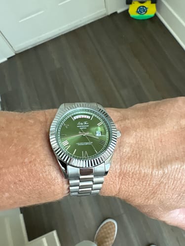 Reviewer showing their Lucky Fours® Santos watch with a green dial and silver band on their wrist.