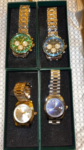 Customer's four Lucky Fours® Santos watches with different colored dials, displayed in their boxes.